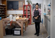 Naomi Hobson standing next to a wooden table and metal sink in her studio Naomi Hobson standing next to a wooden table and metal sink in her studio